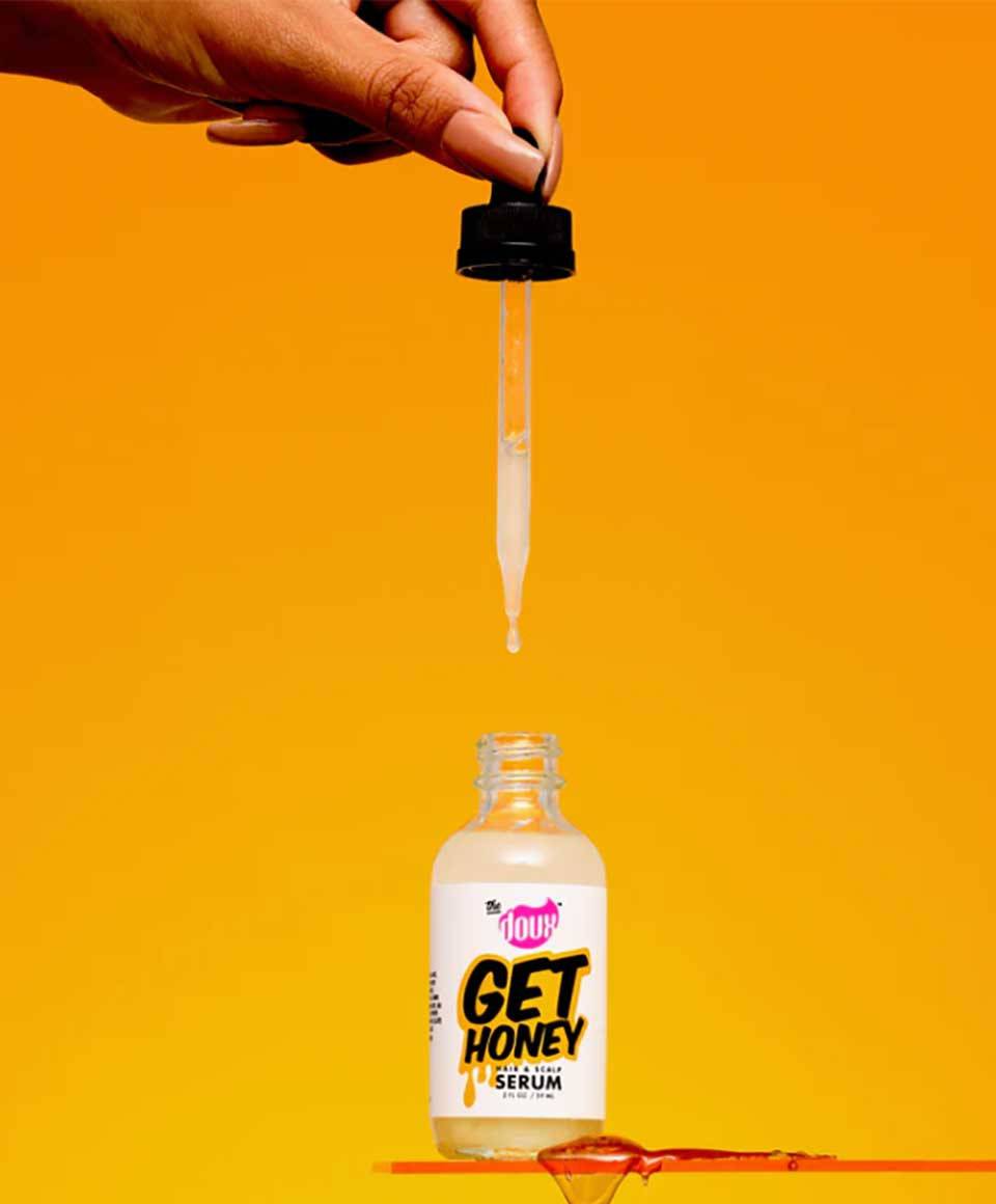 The Doux Get Honey Hair and Scalp Serum in a clear bottle with a pump dispenser, showcasing the nourishing hair serum and oil.