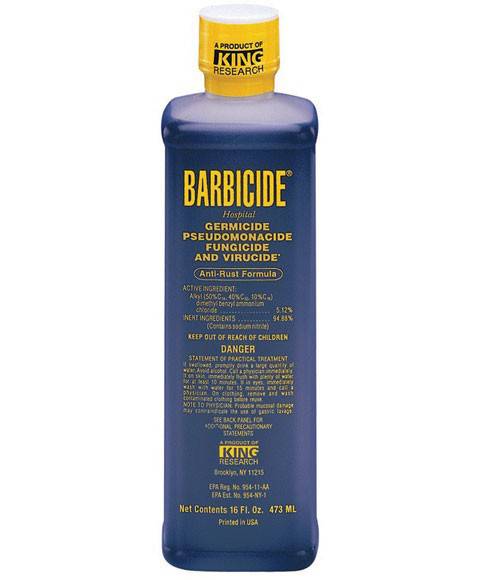 Barbicide disinfectant solution in a clear bottle, used as a salon accessory for sterilizing tools and equipment.