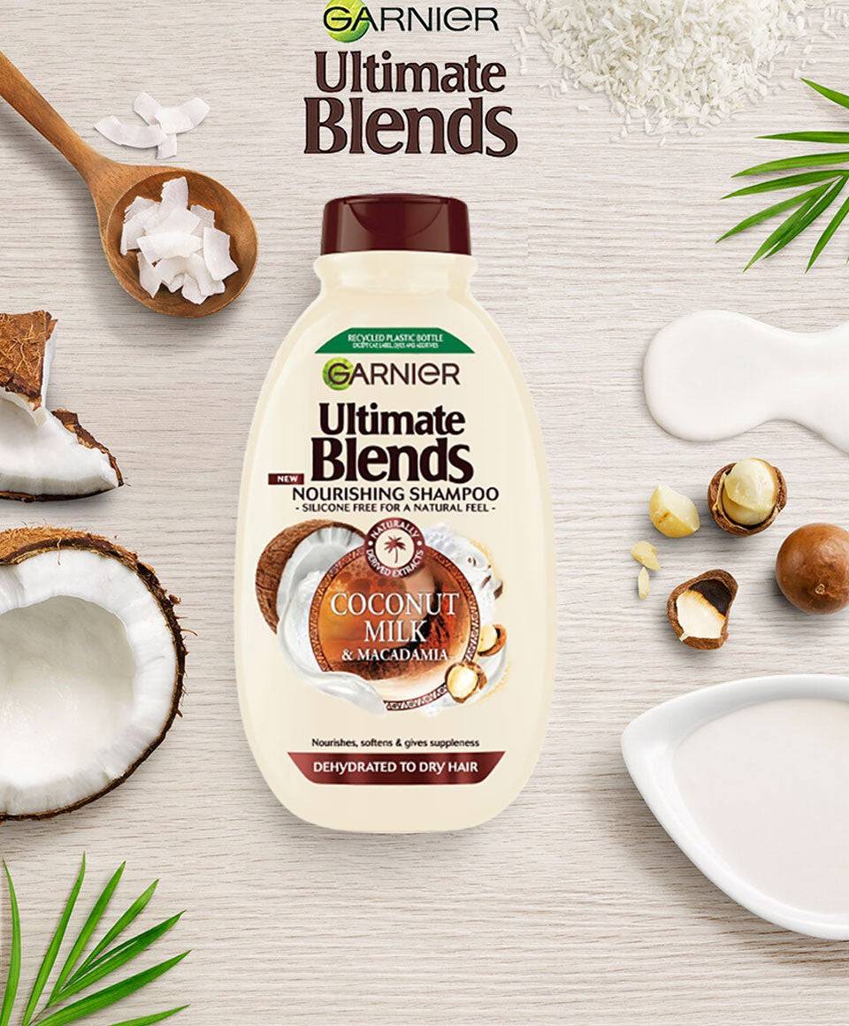 Garnier Ultimate Blends Coconut Milk and Macadamia Nourishing Shampoo bottle with a coconut and macadamia nut background.