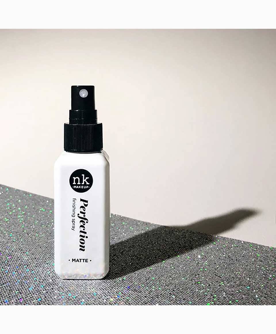 NICKA K NEWYORK NK Perfection Finishing Spray Matte for face makeup, a clear spray bottle with a matte finish, near a makeup brush.