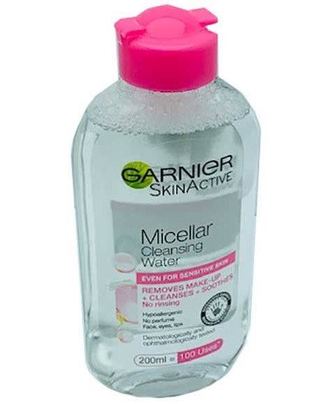 Garnier Skin Active Micellar Cleansing Water bottle with clear liquid, sitting on a white surface, part of Skin Basics line.