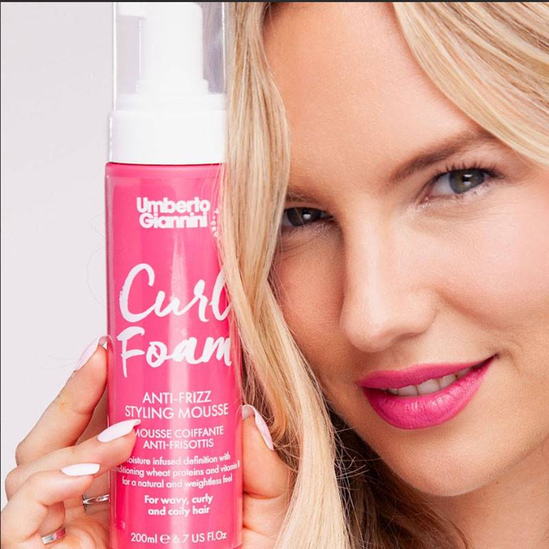Umberto Giannini Curl Foam Anti Frizz Styling Mousse in a bottle, designed to enhance curls and reduce frizz for shiny hair.