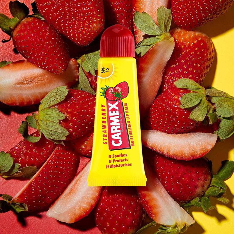 Carma Laboratories Carmex Moisturising Lip Balm Stick in strawberry flavor, featuring a white and red tube with a twist-up design.
