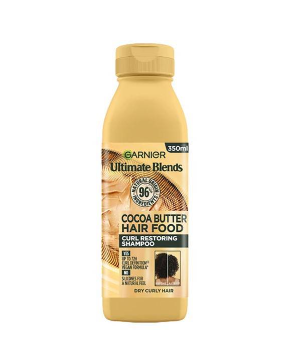 Garnier Ultimate Blends Cocoa Butter Hair Food Curl Restoring Shampoo bottle with label, designed for restoring curly hair.