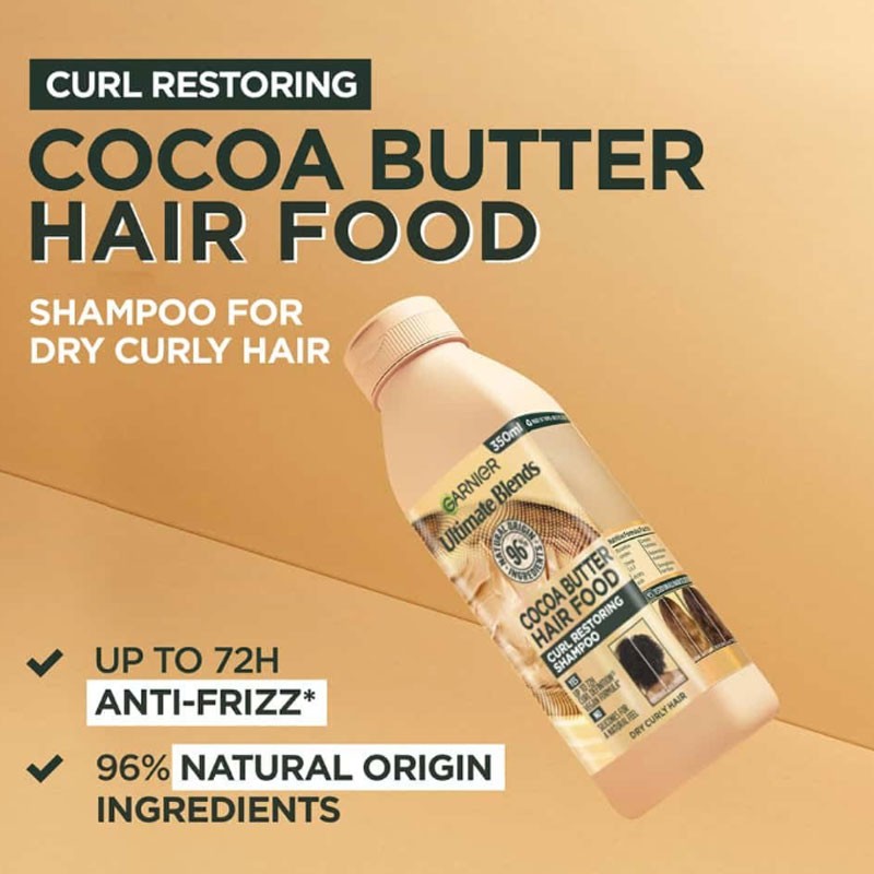 Garnier Ultimate Blends Cocoa Butter Hair Food curl restoring shampoo in a pump bottle with a cocoa butter and hair design.
