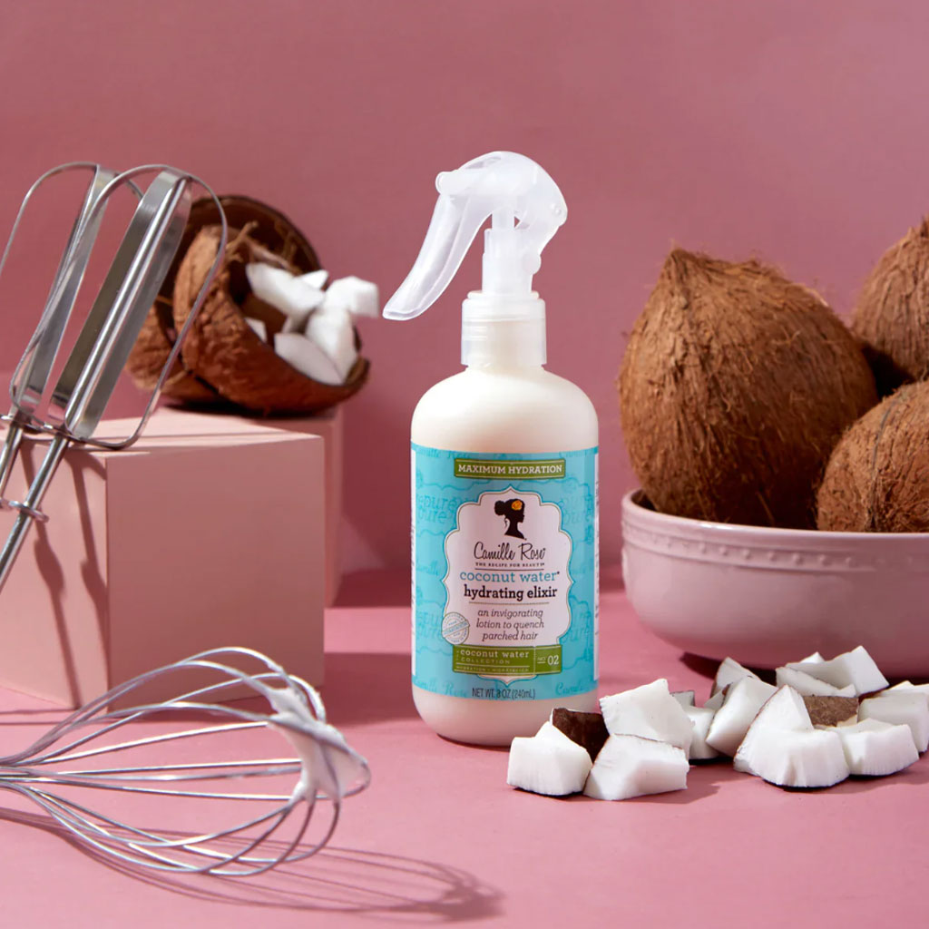 Camille Rose Naturals Coconut Water Hydrating Elixir hair treatment bottle with a pump dispenser and natural ingredients label.