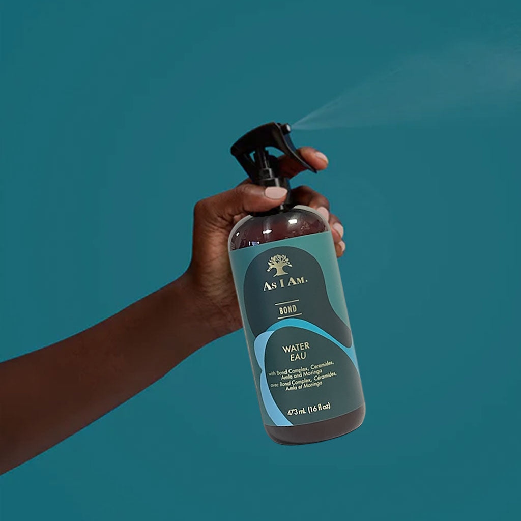 A bottle of As I Am Bond Water Spray hair spray with a clear label, designed for hair bonding and styling.