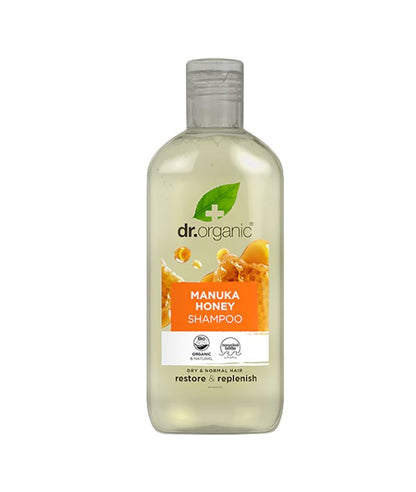 Dr Organic Restore and Replenish Manuka Honey Shampoo bottle with label and blonde hair in the background.